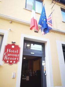 Hotel Cavour Resort في مونكالييري: لافتة منتجع مؤتمرات فندقية وعلامين على مبنى
