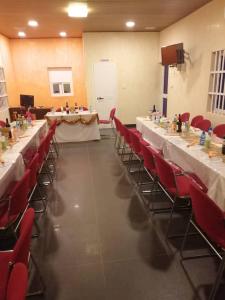 una habitación con mesas largas y sillas rojas en Residence Ivoire Cotonou, en Cotonou