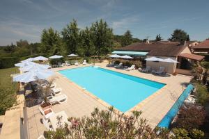 an overhead view of a swimming pool with chairs and umbrellas at Hôtel Le Mas del Pechs - Chambres avec terrasse in Sarlat-la-Canéda
