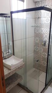 a bathroom with a glass shower with a sink at Hotel Recanto Vip - Antigo Recanto da Serra in Araripina