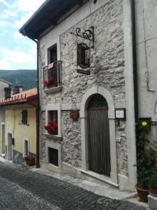 ein altes Steingebäude mit Blumen im Fenster in der Unterkunft Anticarua B&B in Opi