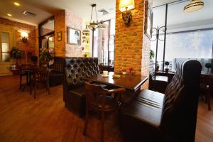 un restaurant avec une table, des chaises et un mur en briques dans l'établissement Eurootel Stavropol, à Stavropol