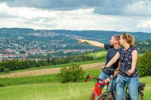 een man en vrouw op een fiets die wijzen naar een stad bij Hirsch Hotel in Ostfildern