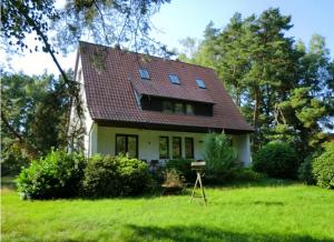una piccola casa bianca con tetto rosso di Ferienwohnung Bachforelle a Neuenkirchen