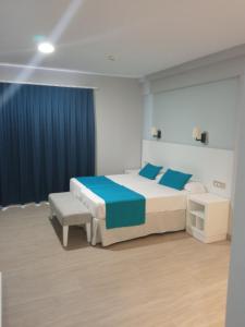1 dormitorio con 1 cama grande y cortinas azules en Apartamentos Oceano - Adults Only - Sólo Adultos, en Costa Teguise