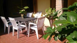a table and chairs on a patio with plants at 49 Le Contesse Ide in Meolo