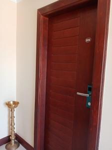 a wooden door with a handle in a room at MercuryFM 101 Yarl Mercury Inn - Jaffna in Jaffna