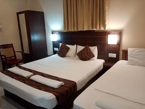 2 Betten in einem Hotelzimmer mit Handtüchern darauf in der Unterkunft MercuryFM 101 Yarl Mercury Inn - Jaffna in Jaffna