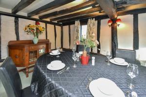 a dining room table with plates and wine glasses at The Game Keepers Cottage in Welwyn