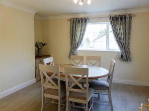 a dining room with a table and chairs and a window at Bolams Holiday Homes by Trident Holiday Homes in Thomastown
