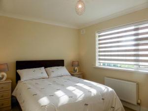 a bedroom with a large white bed and a window at Bolams Holiday Homes by Trident Holiday Homes in Thomastown