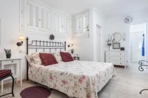 Dormitorio blanco con cama con almohadas rojas en Apartamento 24 Edificio Canopus, en Alcudia