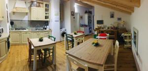 una cucina con tavoli e sedie in legno in una stanza di B&B Ca'rina a Rovereto