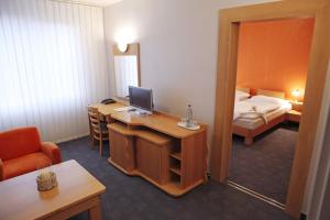 a hotel room with a desk with a computer and a bed at Hotel Luna in Žiar nad Hronom