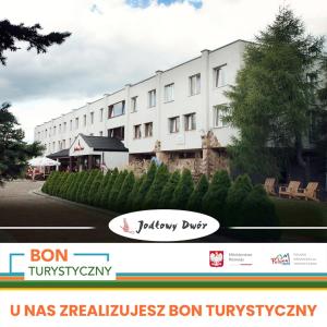 un gran edificio blanco con un cartel delante en Pensjonat "Jodłowy Dwór" en Bieliny