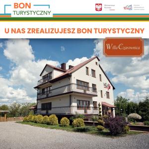 un grand bâtiment blanc avec un panneau indiquant wcas raisellez bon tum dans l'établissement Willa Czarownica, à Nowa Słupia