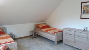 a bedroom with two twin beds and a dresser at Ferienwohnung Am Orlbach in Schönstedt