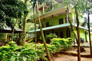 um edifício na selva com árvores e arbustos em Jungleview Home Stay em Idukki