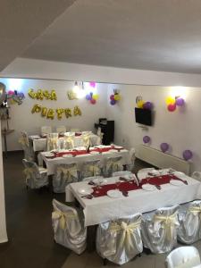 a room with white tables and balloons on the wall at Pensiunea Q in Fieni