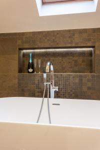 a kitchen sink with a faucet and a bottle of wine at Szőnyi Garden Hotel Pest in Budapest