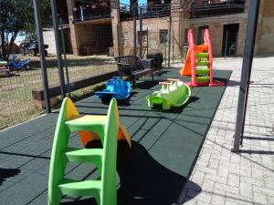 un parque infantil con coloridos equipos de juego en una acera en Elicriso, en Casteggio