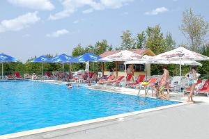 a swimming pool with chairs and umbrellas and people standing around it at Panorama Hotel in Apriltsi