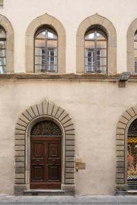 a building with two arches and a wooden door at Palazzo D'Ambra Residenza d'Epoca in Florence