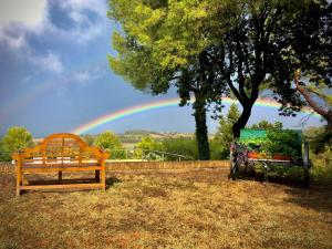 Il Colle delle Terrazze في فانو: قزاز في السماء مع مقعد وشجرة