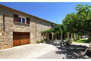 Casa de piedra con puerta de madera y entrada en Villa Crever, en Pollensa