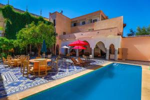 a resort with a pool and tables and chairs at Palais Shazam & SPA in Fez