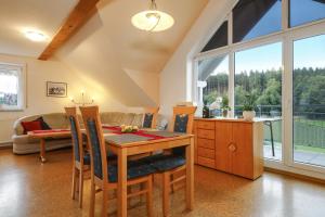 eine Küche und ein Esszimmer mit einem Tisch und Stühlen in der Unterkunft Ferienwohnung Merk in Neukirch