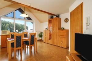 eine Küche und ein Esszimmer mit einem Tisch und Stühlen in der Unterkunft Ferienwohnung Merk in Neukirch