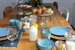 une table en bois avec des assiettes et des bols de nourriture et de lait dans l'établissement B & B Meet the Dutch, à Ridderkerk