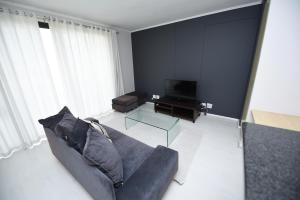 a living room with a couch and a television at The Island Club Apartment in Cape Town