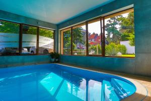 a large swimming pool in a house with windows at Ośrodek wypoczynkowy Balt-Tur Feel Well Resort in Jastrzębia Góra