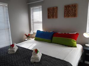 a bedroom with a large bed with colorful pillows at 16 Rhodes-North Self Catering Apartment & Studio in Stellenbosch