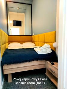 sypialnia z dużym lustrem nad łóżkiem w obiekcie Kapsuły Bello ApartHostel w Warszawie