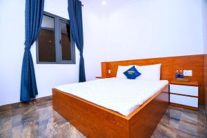 1 dormitorio con 1 cama con cabecero de madera en SUN HOTEL en Thu Dau Mot