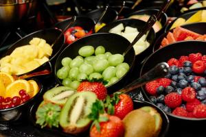 a bunch of bowls of fruit on a buffet at Hotel Estheréa in Amsterdam