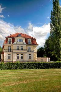 une grande maison blanche avec un toit rouge dans l'établissement Hotel Dirks am Schloss, à Bad Pyrmont