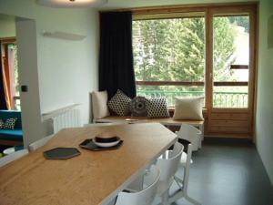 a dining room with a table and a large window at Les Lauzières in Arc 1800