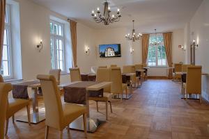 un comedor con mesas y sillas y una lámpara de araña en Hotel Dirks am Schloss, en Bad Pyrmont