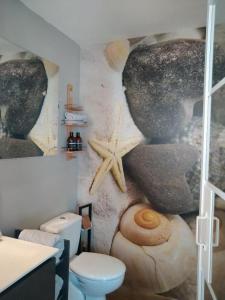 a bathroom with a wall mural of rocks and a toilet at Le Belvedere des Remparts in Langres