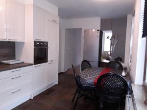 a kitchen with a table and chairs and a kitchen with white cabinets at Stadswoning Roermond in Roermond