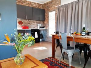 a kitchen with a table and a vase of flowers on a table at 16 Rhodes-North Self Catering Apartment & Studio in Stellenbosch