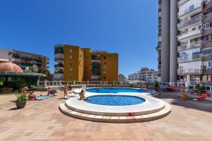 een zwembad in het midden van een stad met gebouwen bij Apartamento Mirador in Torremolinos