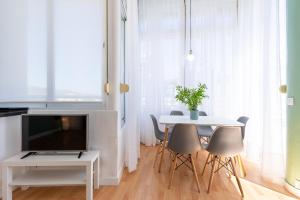 een woonkamer met een tafel met stoelen en een televisie bij Apartamento Mirador in Torremolinos