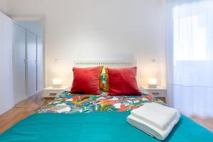 a bedroom with a blue bed with red pillows at Apartamento Mirador in Torremolinos