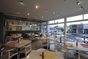 - un restaurant avec des tables, des chaises et de grandes fenêtres dans l'établissement Hotel Velvet Plaza, à Guadalajara