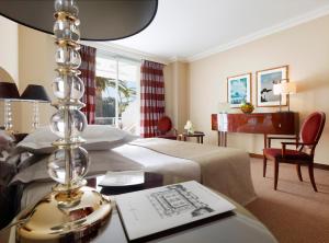 a hotel room with a bed and a desk with a table sidx sidx at Hôtel Juana in Juan-les-Pins